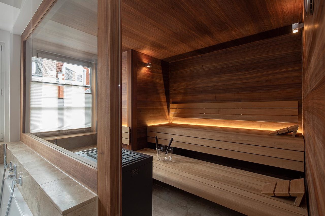 Design Sauna für Zuhause im Altbau mit Dachschräge und Glasfront in Nussbaum